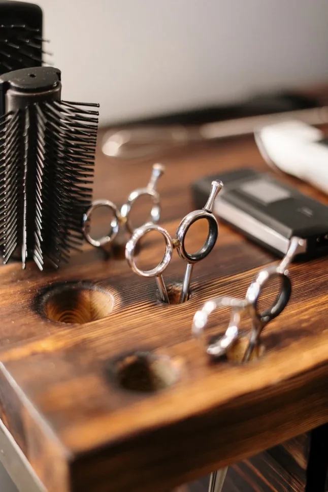 Ciseaux de coiffure rangés sur le comptoir en bois du salon Chez Rachid